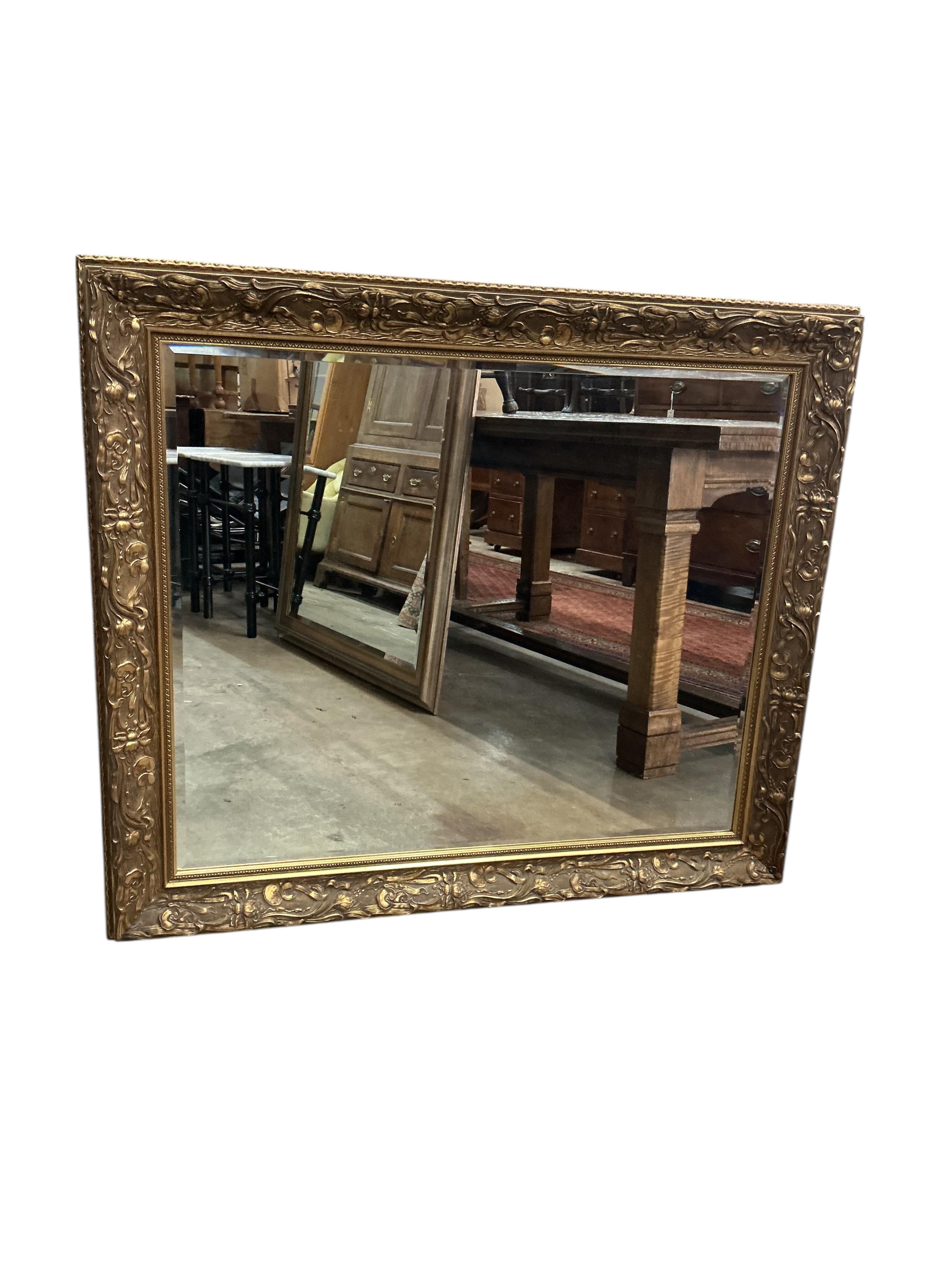 A reproduction Art Nouveau style gilt composition wall mirror, width 110cm, height 94cm